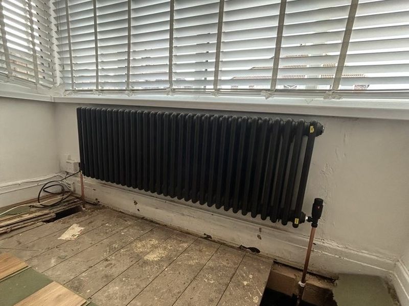 New anthracite column radiator under a bay window