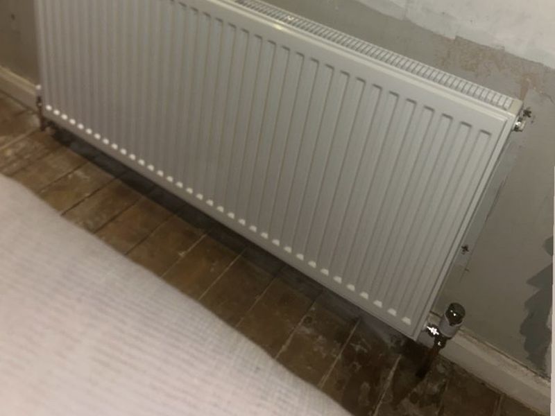 New panel radiator fitted on a bedroom wall